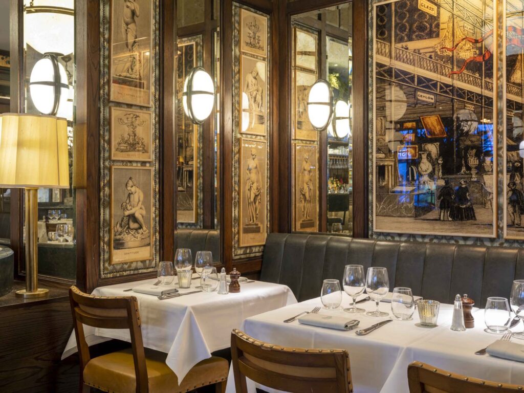 A close up image taken in The Ivy Kensington. In the picture you can see two tables and the room is dimly lit