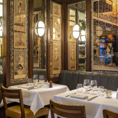 A close up image taken in The Ivy Kensington. In the picture you can see two tables and the room is dimly lit