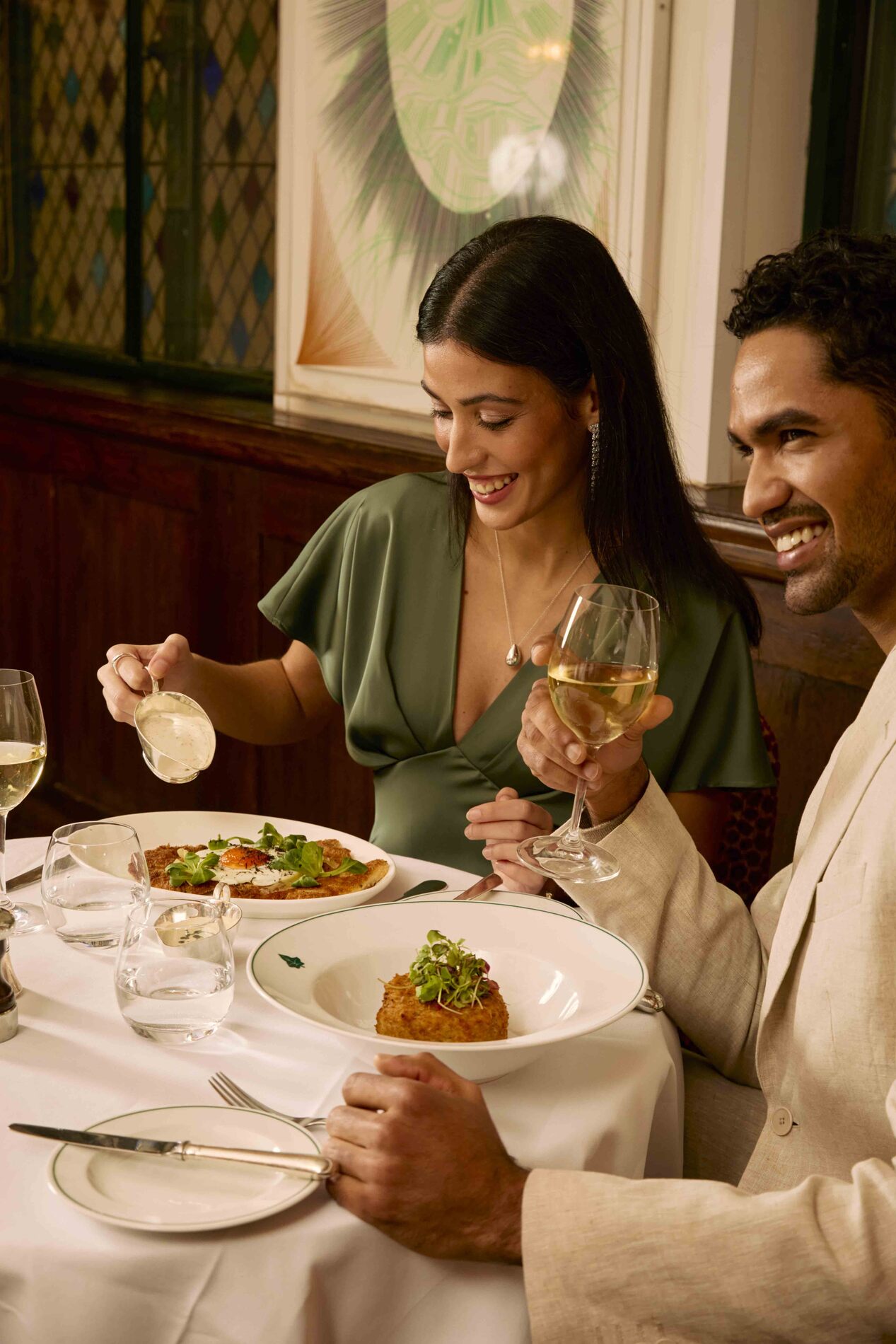 A guest pouring sauce on her meal at The Ivy.